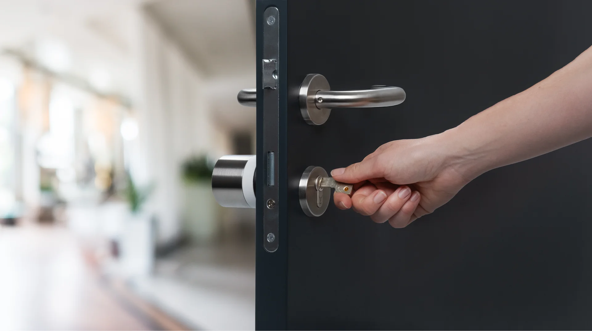 Mano che inserisce la chiave nella porta con Nuki Smart Lock.