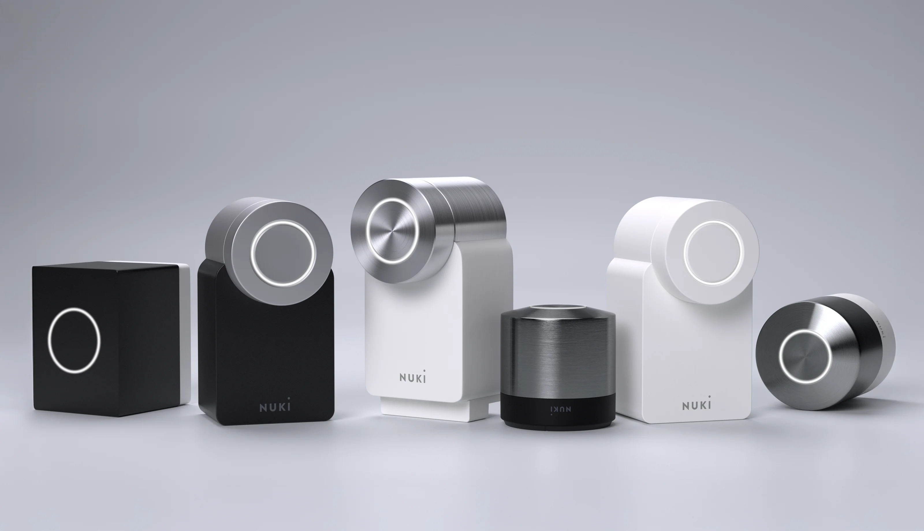 Il portfolio Nuki allineato su uno sfondo grigio: il Nuki Bridge e tutti gli Smart Lock.