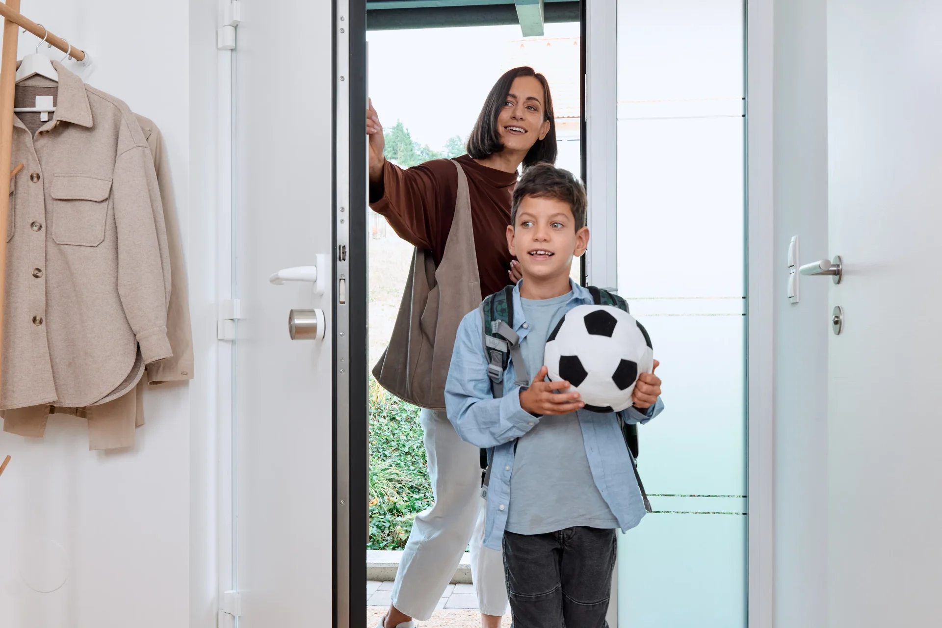 Mamma felice e figlio felice che tornano a casa con un pallone da calcio.